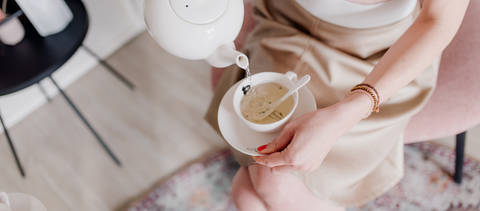 Rozenknop thee zetten in wit porselein theekop