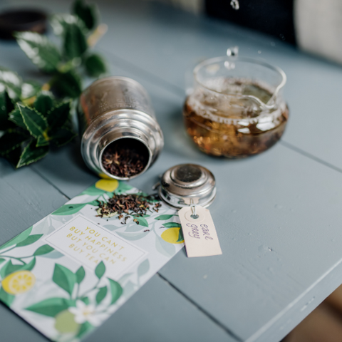 Losse earl grey thee in theeblikje met theepot op de achtergrond